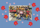 Grupa dzieci z kwiatami i sercami.